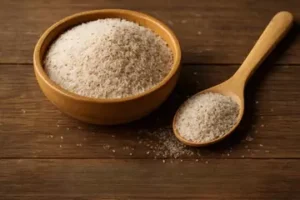 bowl filled with psyllium husk and a wooden spoon placed beside it.